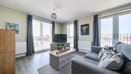 Living room with sofas, coffee table, television, and windows.