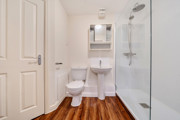 Bathroom with shower enclosure, toilet, sink and mirrored cabinet.