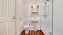 Bathroom with shower enclosure, toilet, sink and mirrored cabinet.