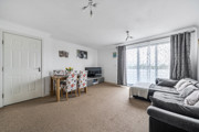 Living room with sofas, dining table and chairs, carpet, and balcony door with curtains.