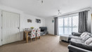 Living room with sofas, dining table and chairs, carpet, and balcony door with curtains.