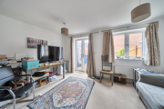 Bright living room with sofas, TV stand, french door and large window with curtains.