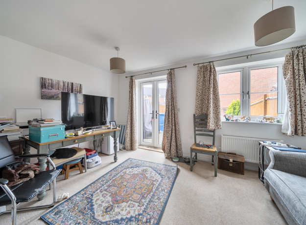 Bright living room with sofas, TV stand, french door and large window with curtains.