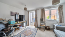 Bright living room with sofas, TV stand, french door and large window with curtains.