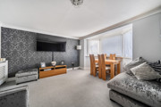 Living room with sofa, television and dining table by the window.