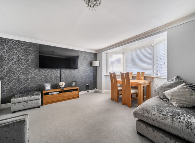 Living room with sofa, television and dining table by the window.
