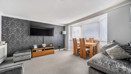 Living room with sofa, television and dining table by the window.