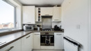 Kitchen with worktops, storage units and integrated oven.
