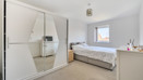 Bedroom with mirrored wardrobe, bed, and chest of drawers.