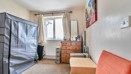 Single bedroom in a modern home with window, carpeted flooring, chest of drawers and built-in storage space.