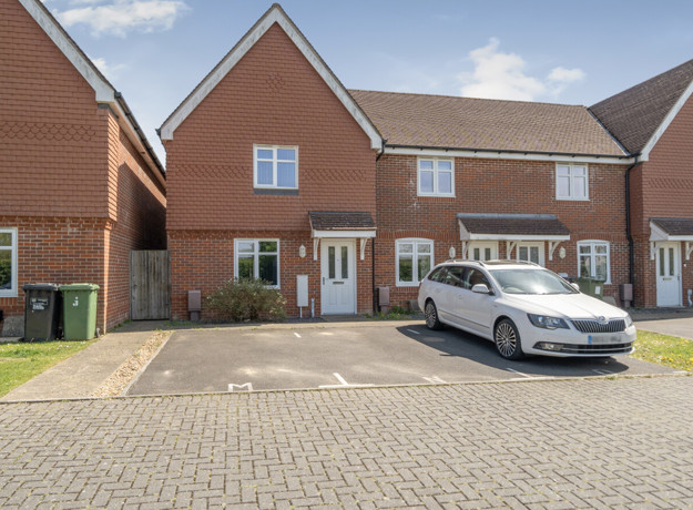 Row of modern red brick houses with driveway parking on a residential estate