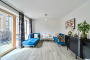 Living room with seating, curtains and balcony access.