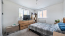 Bedroom with double bed, chest of drawers, TV and windows.