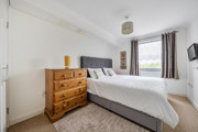 Bedroom with double bed, chest of drawers, and window.