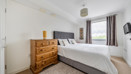 Bedroom with double bed, chest of drawers, and window.