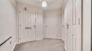 Hallway with multiple doors, radiator and carpeted flooring.