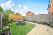 Garden with lawn, patio seating area and fenced boundary.