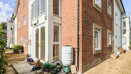 Exterior corner view of a brick apartment building with pathways.