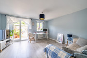 Living room with sofas, dining table, and patio doors to the garden.