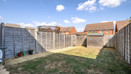 Enclosed rear garden with lawn, paved path, shed and wooden fencing.