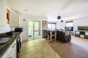 Open-plan kitchen and living area with glass doors to a balcony.