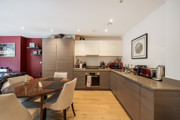Open-plan kitchen with dining table, cabinets, and countertop appliances.
