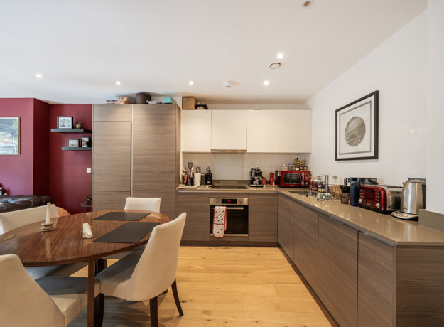 Open-plan kitchen with dining table, cabinets, and countertop appliances.