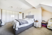 Spacious bedroom with double bed, sloped ceiling and fitted wardrobes