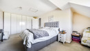 Spacious bedroom with double bed, sloped ceiling and fitted wardrobes