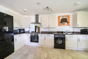 Kitchen with white cabinets, appliances, and a washing machine.