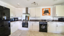 Kitchen with white cabinets, appliances, and a washing machine.