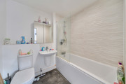 Bathroom with bathtub, shower screen, toilet, and sink.