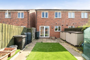 Rear garden with a lawn, fencing and outdoor storage.