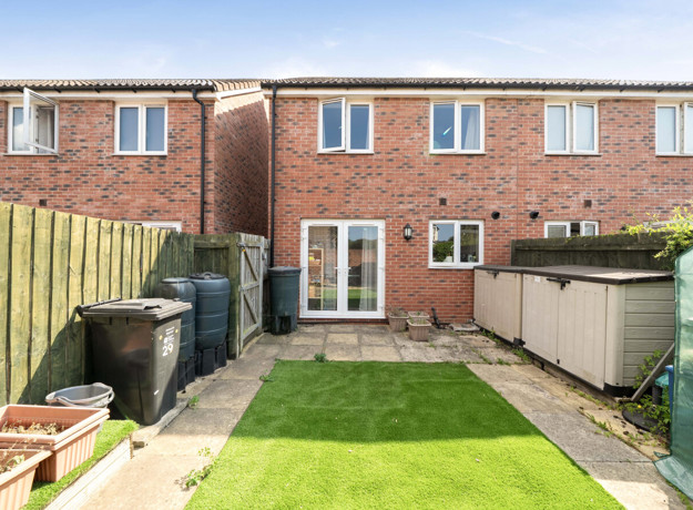 Rear garden with a lawn, fencing and outdoor storage.