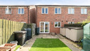 Rear garden with a lawn, fencing and outdoor storage.