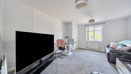 Living room with sofa, TV, glass dining table with chairs, carpeted floor and window