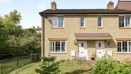 Two storey end-of-terrace brick house with front garden, path and white door.