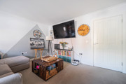 Bright living room with sofa, TV, storage chest and white walls