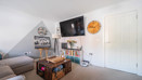 Bright living room with sofa, TV, storage chest and white walls
