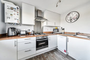 Modern kitchen with white cabinets, wooden-effect worktops, backsplash and appliances