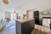 Open-plan kitchen and living area with island unit and seating.