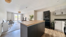 Open-plan kitchen and living area with island unit and seating.