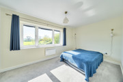 Double bedroom with grey carpet, neutral decor and window