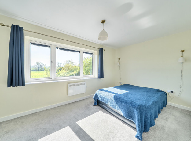 Double bedroom with grey carpet, neutral decor and window