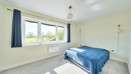 Double bedroom with grey carpet, neutral decor and window