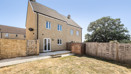 Rear garden with lawn and fenced boundaries behind the house.