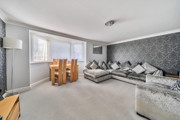 Living and dining area with corner sofa, table and chairs.
