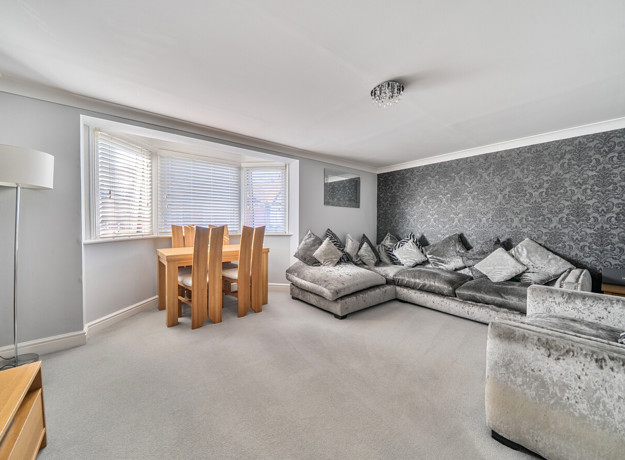 Living and dining area with corner sofa, table and chairs.