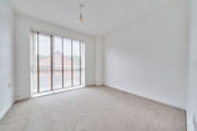 Bedroom with carpeted floor and large floor-to-ceiling window.
