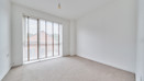 Bedroom with carpeted floor and large floor-to-ceiling window.